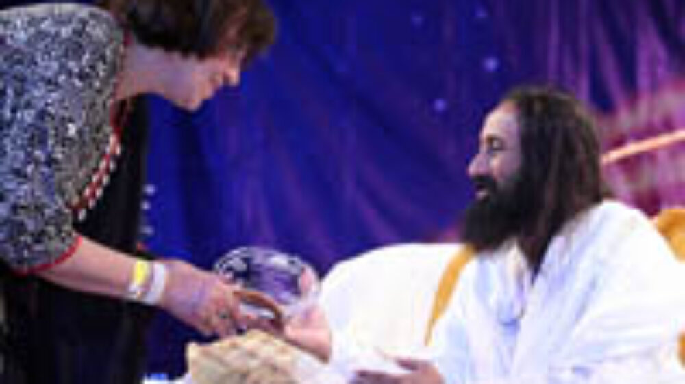 Pam Kwatra receiving Award from Sri Sri Ravi Shankar